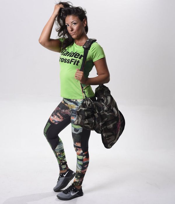 Woman performing a dynamic cardio exercise in a modern studio.